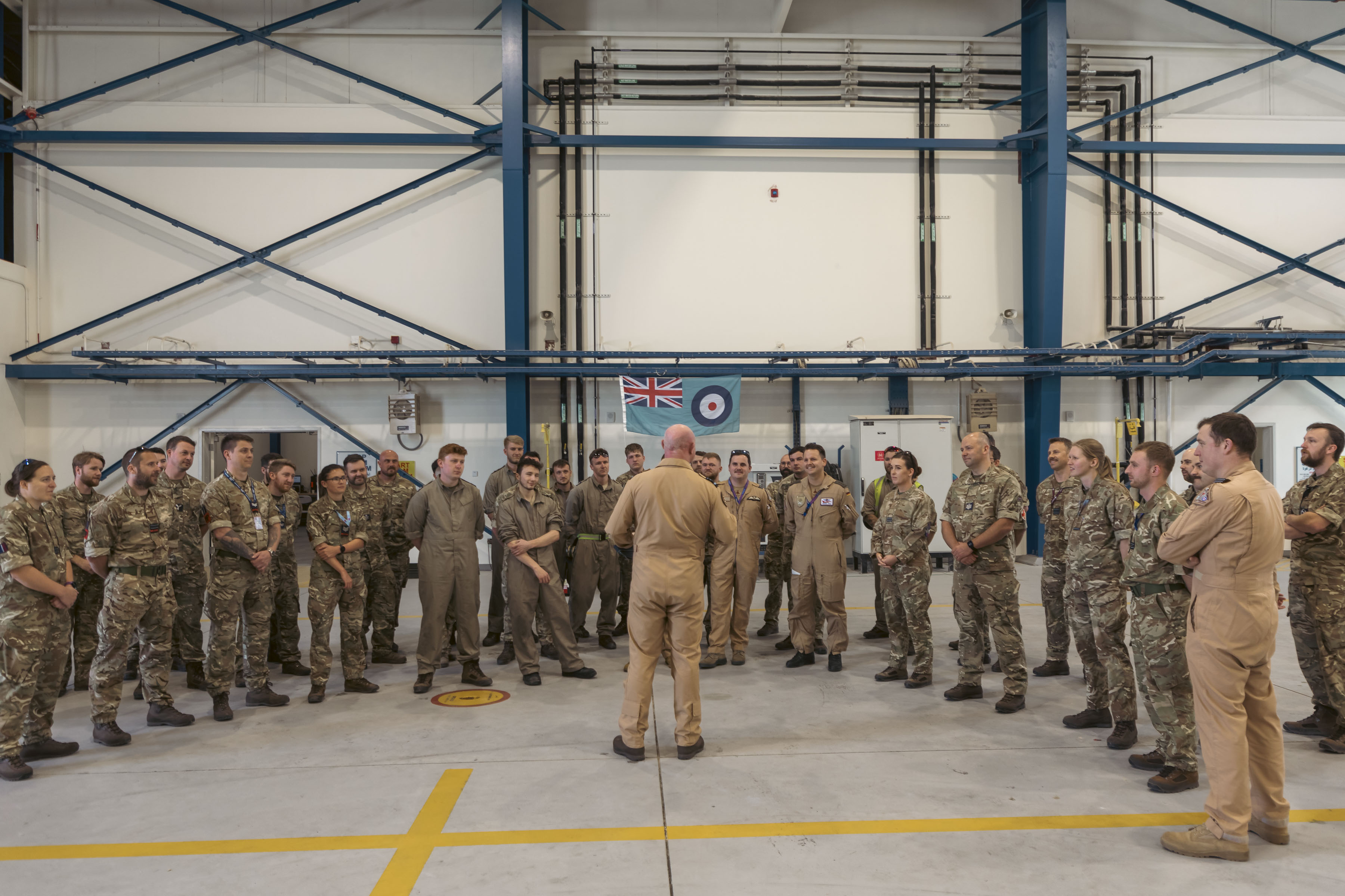 Image shows RAF aviators inside a hangar.